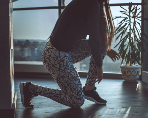 Woman in patterned grey sport pants performing workout exercises